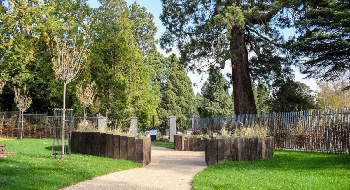 The Brookwood Reflective Garden behind Brookwood station, with planters made from old railway sleepers and the cemetery gates beyond